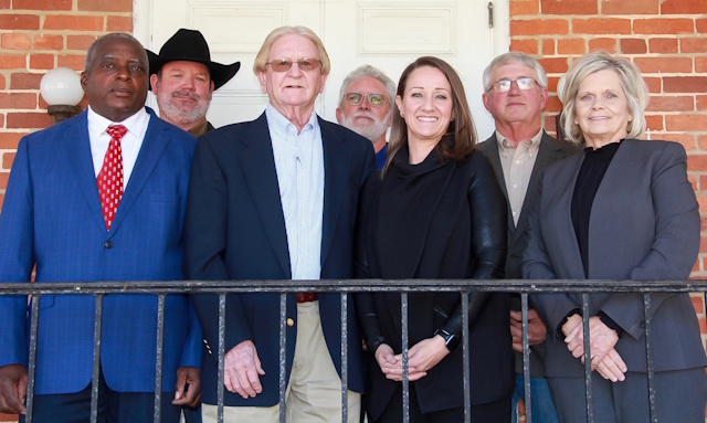 Supervisors group photo standing in front of a brick wall